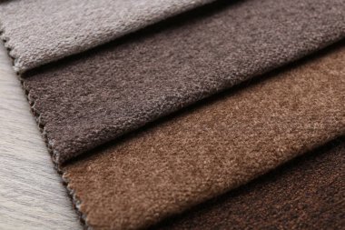 Tahta masadaki farklı kumaşlardan örnekler, yakın plan.