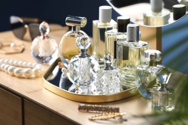 İçerideki ahşap masada parfüm şişeleri.