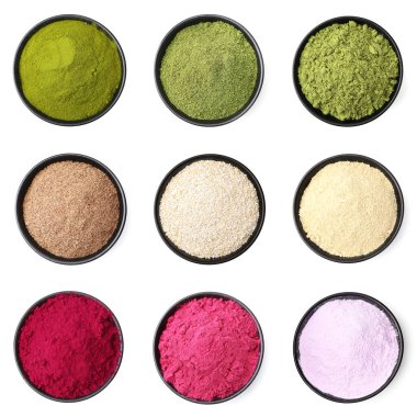 Beyaz arka planda kaselerde farklı süper yiyecek tozları var. Üst görünüm