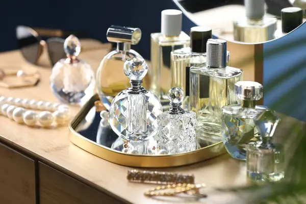 İçerideki ahşap masada parfüm şişeleri.