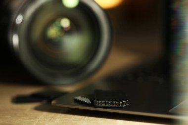 SD hafıza kartları, dizüstü bilgisayar ve fotoğraf makinesi ahşap masada, yakın plan.