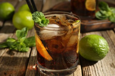 Küba libre kokteylini ahşap masada nane şekeri ile tazeliyorum.