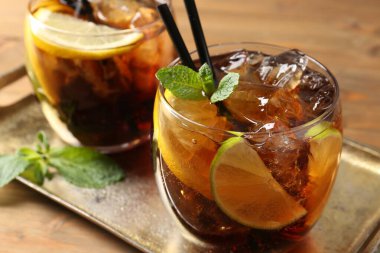 Küba libre kokteylini ahşap masada nane şekeri ile tazeliyorum.