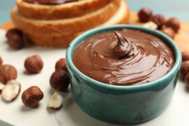 Çikolatalı fındık ezmesi ve fındıklar masada, yakın plan.