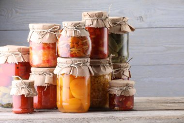 Ahşap masada farklı turşu ürünleri olan bir sürü kavanoz.