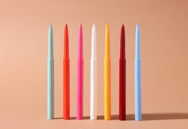 Bej arka planda renkli göz kalemleri, yakın plan