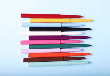 Açık mavi arka planda renkli göz kalemleri, düz yatıyordu.