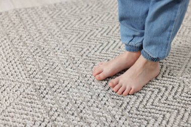 Evdeki gri halıdaki kız, yakın plan. Metin için boşluk