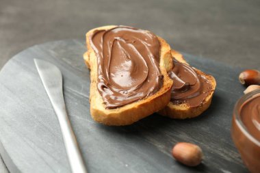 Lezzetli çikolatalı tostlar ve gri masada fındıklar, yakın plan.