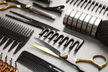 Gri masadaki farklı kuaför aletleri, yakın plan.