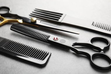 Gri masadaki farklı kuaför aletleri, yakın plan.