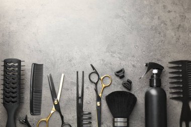 Gri masadaki farklı kuaför aletleri, düz yatış. Metin için boşluk