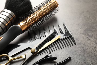 Gri masadaki farklı kuaför aletleri, yakın plan.