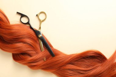 Bej arka planda saç tokası ve makas, üst manzara. Metin için boşluk