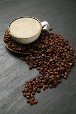 Kahve fincanda, fasulye de siyah masada, yukarıda.