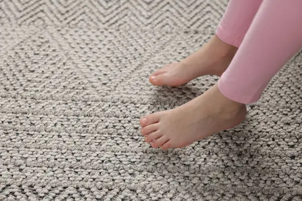 Evdeki gri halıdaki kız, yakın plan.