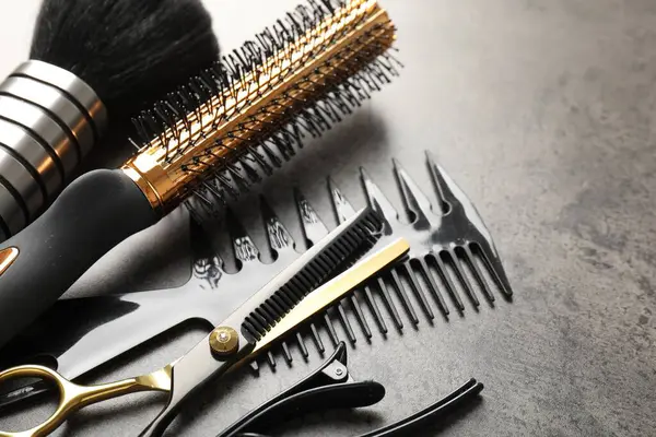 Gri masadaki farklı kuaför aletleri, yakın plan.