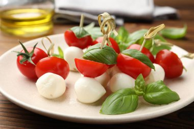 Ahşap masada mozarella, domates ve fesleğen ile aperatifler, yakın plan.