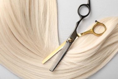 Sarı saç tokası ve makas açık gri arka plan, üst görünüm