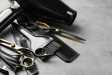 Gri masadaki farklı kuaför aletleri, yakın plan. Metin için boşluk