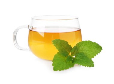 Cam bardakta Aromatik limon merhemi çayı ve beyaz bardakta taze yapraklar.