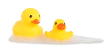 Tatlı plastik ördekler ve köpükler ayna yüzeyinde beyaz arka planda