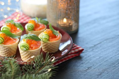 Lezzetli kanepeler ve mavi ahşap masada köknar dalları, yakın plan. Metin için boşluk