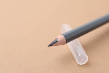 Bej arka planda gri kaş kalemi, yakın plan. Metin için boşluk
