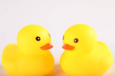 Beyaz arka planda iki sevimli lastik ördek, yakın plan.