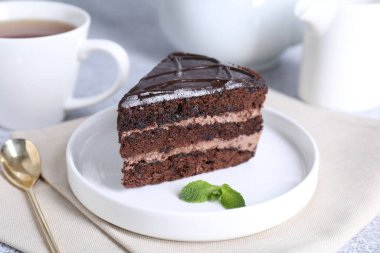 Gri masadaki naneli ve kaşıklı lezzetli çikolatalı pasta.