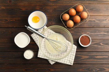 Krem şanti yapıyorum. Kase, çırpı ve malzemeler ahşap masada, düz yatıyordu.