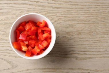 Tahta masadaki kasede taze kırmızı dolmalık biber parçaları. Metin için boşluk