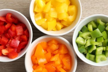 Taze renkli dolmalık biberler ahşap masadaki kaselerde, düz yatıyordu.