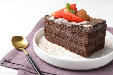 Çilekli, bademli ve naneli bir dilim lezzetli çikolatalı pasta.