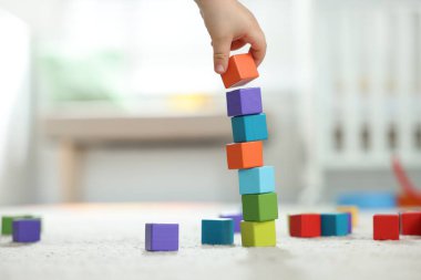 Evde renkli küplerle oynayan sevimli küçük çocuk, yakın plan.