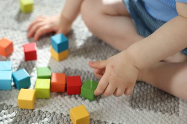 Evde renkli küplerle oynayan sevimli küçük çocuk, yakın plan.