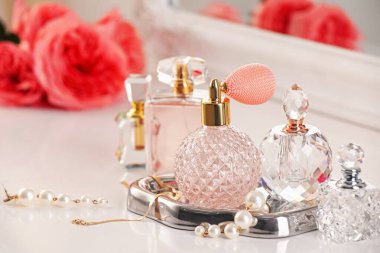 Farklı parfümlerden, aksesuarlardan ve çiçeklerden oluşan şişeler.