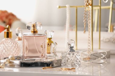 İçerideki tuvalet masasında farklı parfüm ve aksesuar şişeleri, yakın plan.