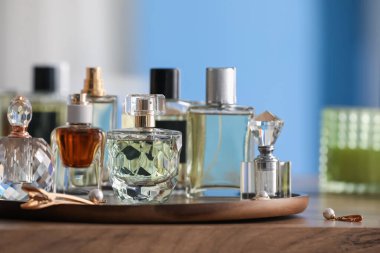 Farklı parfüm şişeleri ve aksesuarlar ahşap masada, yakın plan.