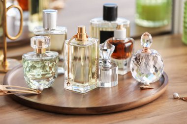 Farklı parfüm şişeleri ve aksesuarlar ahşap masada, yakın plan.