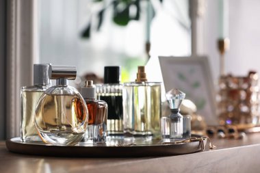 Farklı parfüm şişeleri ve aksesuarlar ahşap masada, yakın plan.