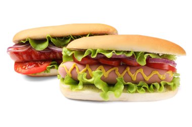 Beyaz arka planda domatesli, soğanlı, marullu ve hardallı lezzetli sosisliler.