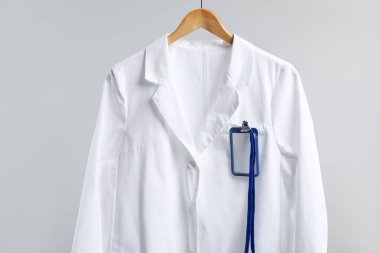 Gri arka planda askısı olan doktorun ceketi