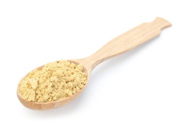 Kuru zencefil tozu beyaz kaşıkta izole edilmiş.