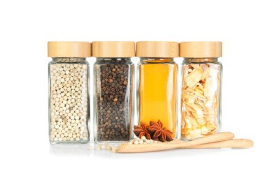 Beyaz kavanozlardaki farklı aromatik baharatlar.