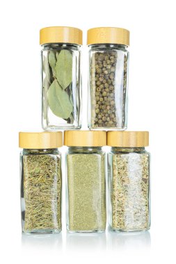 Beyaz kavanozlardaki farklı aromatik baharatlar.