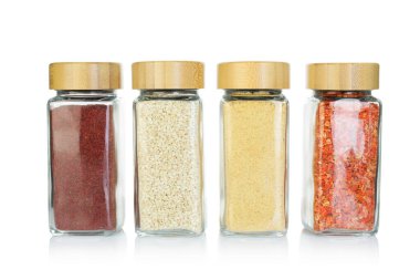 Beyaz kavanozlardaki farklı aromatik baharatlar.