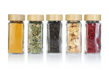 Beyaz kavanozlardaki farklı aromatik baharatlar.