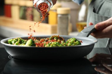 Mutfağa baharat ekleyen kadın, yakın plan.