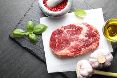 Siyah masada çiğ et ve baharat var.